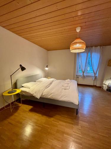 a bedroom with a bed and a lamp and a window at Zurich Essentials Simple Apartment in Zurich