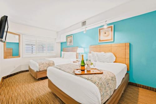 een slaapkamer met 2 bedden en een blauwe muur bij Beach Cove Resort Unit 625 Corner Condo with Direct Oceanfront Balcony in Myrtle Beach