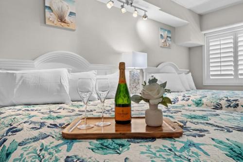 une bouteille de vin et deux verres de vin sur un lit dans l'établissement Beach Cove Resort Unit 1106 - End Condo with Direct Oceanfront Balcony, à Myrtle Beach