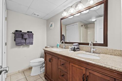 une salle de bains avec lavabo, toilettes et miroir dans l'établissement Beach Cove Resort Unit 1106 - End Condo with Direct Oceanfront Balcony, à Myrtle Beach