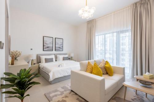a white bedroom with a bed and a couch at Elegant Studio Near Yas Mall and Ferrari World in Yas Island