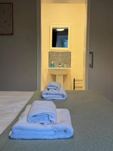 a bedroom with towels on a bed with a sink at Modern 2BR Blairgowrie Cottage in Blairgowrie