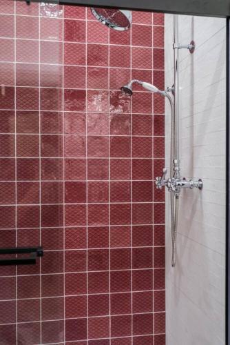 a bathroom with a shower with red tiles at Scarlet Suite in Sedalia