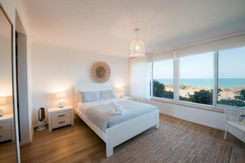 a bedroom with a bed with a view of the ocean at Oceana - A Panoramic Beachfront Escape for Groups in Port Elliot