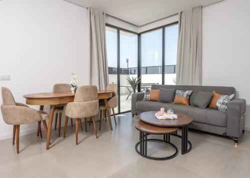 salon z kanapą i stołem w obiekcie רוי סוויטות בוטיק - 2 סוויטות עם מרפסת פרטית w mieście Jawne’el