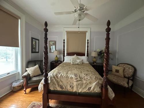 a bedroom with a bed and a ceiling fan at Wisteria Suite -The Belvedere Inn in Oswego