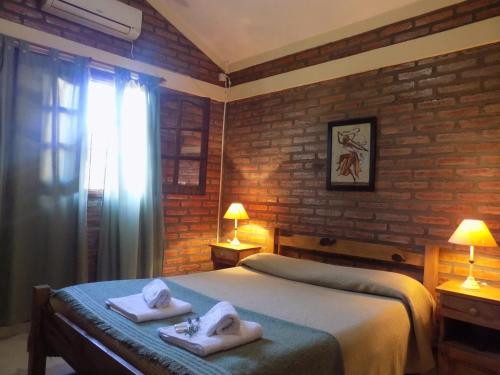 a bedroom with a bed with towels on it at Cabañas La Morada de Tanti in Tanti