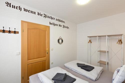 2 Betten in einem Zimmer mit Schild an der Wand in der Unterkunft Bungalow Seestern in Malchow