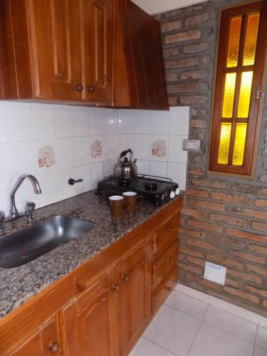 a kitchen with a sink and a counter top at Cabañas La Morada de Tanti in Tanti