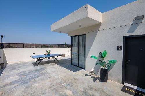 patio ze stołem do ping ponga w budynku w obiekcie רוי סוויטות בוטיק - 2 סוויטות עם מרפסת פרטית w mieście Jawne’el