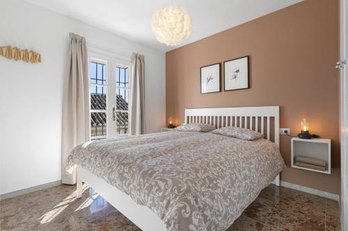 ein Schlafzimmer mit einem großen Bett und einem Fenster in der Unterkunft Puebla Aida II in Santa Fe de los Boliches