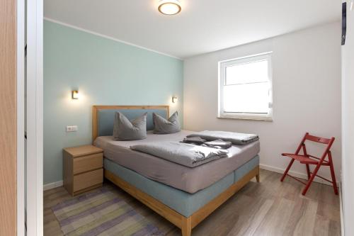 une chambre avec un lit et une chaise rouge dans l'établissement Girlitz Nest, à Röbel