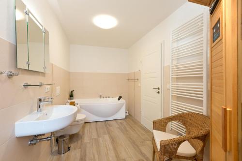 une salle de bain avec un lavabo blanc et une baignoire dans l'établissement Girlitz Nest, à Röbel