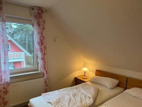 unter den Kiefern 99 في Marienfelde: غرفة نوم بها سريرين ونافذة