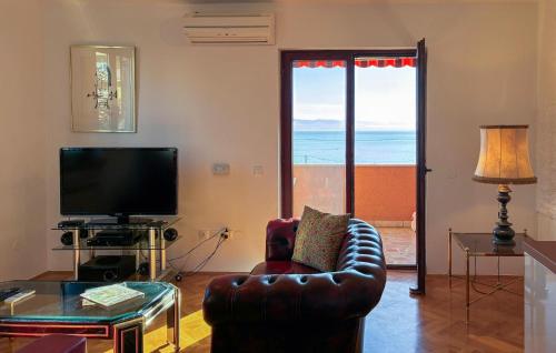 ein Wohnzimmer mit einem Ledersessel und einem TV in der Unterkunft Beautiful Apartment In Opric With Wifi in Ika