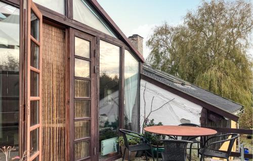 a patio with a table and chairs and a window at 2 Bedroom Cozy Apartment In Hundested in Kikhavn