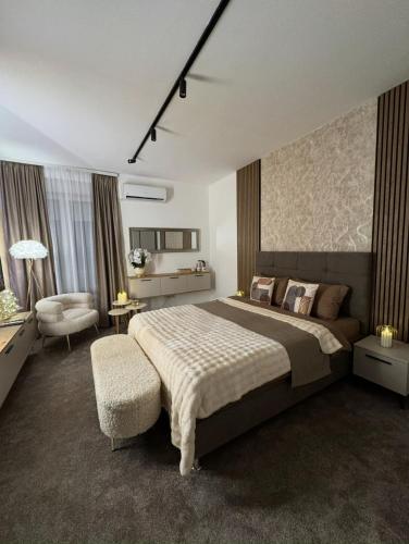 a bedroom with a large bed and a chair at SpaNish FoROOM 1 in Niš