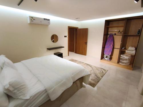 una camera da letto con un letto bianco e un armadio di Ram101 a Gedda
