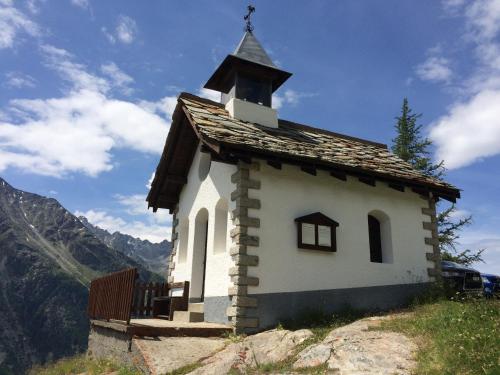 a small church sitting on top of a hill at Chalet Sunstar in Saas-Grund