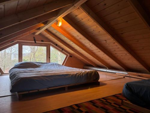 a bed in a room with a large window at De Smidse in Haren