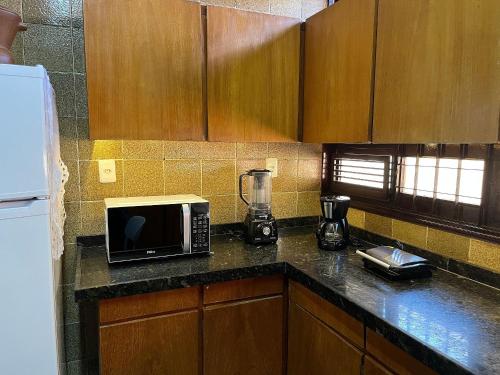 a kitchen with a counter top with a microwave at Studios Casamarela in Mossoró
