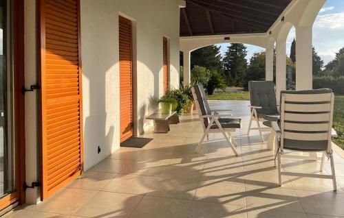 eine Veranda mit Stühlen und einem Tisch auf einem Haus in der Unterkunft Beautiful Apartment In Gdinj in Gdinj