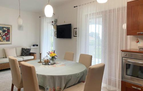 ein Wohnzimmer mit Tisch und Stühlen und eine Küche in der Unterkunft Beautiful Apartment In Gdinj in Gdinj