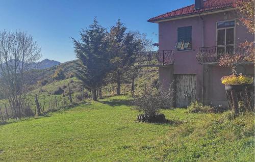a pink house with a balcony and a yard at Lovely Home In Caranzavarese Ligure in Groppo