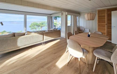 Una sala de estar con una mesa y sillas y un sofá. en Amazing Home In Gressvik With Wifi, en Slevik