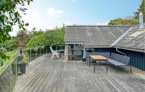 4 Bedroom Gorgeous Home In Tranekær في Stoense: سطح مع طاولة ومقعد على المنزل