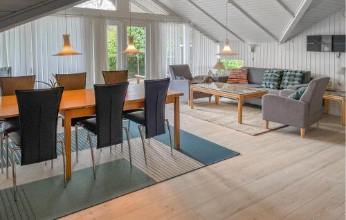 4 Bedroom Gorgeous Home In Tranekær في Stoense: غرفة معيشة مع طاولة وكراسي خشبية