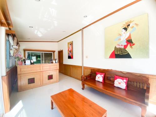 a living room with a bench and a painting on the wall at Na Soi 5 Chiangkhan in Chiang Khan