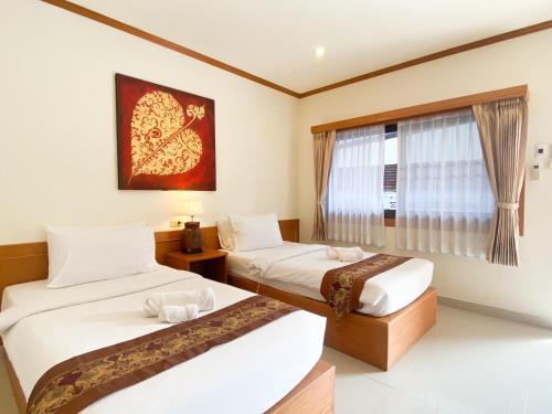 two beds in a room with a window at Na Soi 5 Chiangkhan in Chiang Khan