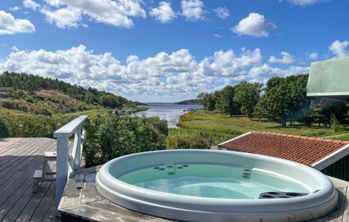 a bath tub on a deck with a view of a river at 5 Bedroom Cozy Home In Onsala in Draget