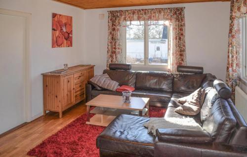 ein Wohnzimmer mit einem Ledersofa und einem Couchtisch in der Unterkunft 2 Bedroom Nice Home In Virserum in Virserum