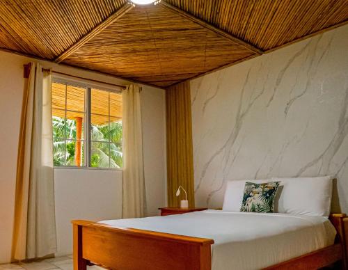 a bedroom with a bed and a window at Casa de Campo Rio Piedra Farm Portobelo in María Chiquita