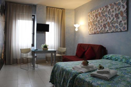 a hotel room with a bed and a table and a desk at Triana Historic Center in Seville