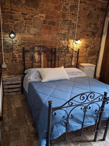 a bedroom with a black bed in a brick wall at Il Vico holiday home in Serra San Bruno