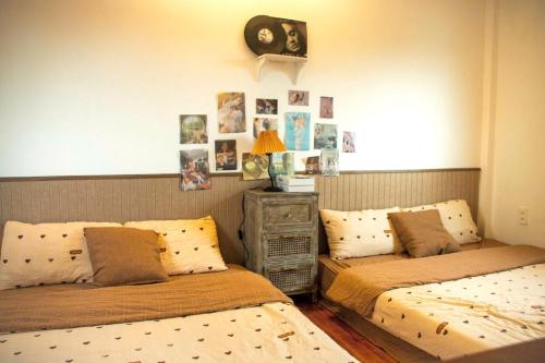 a bedroom with two beds and a clock on the wall at Chái Nho Homestay in Da Lat