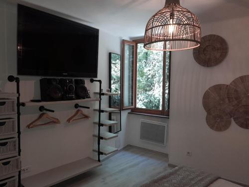 サン・ジャン・デュ・ガルにあるMaison cévenole - Centre ville - Arrivée flexibleのテレビ、棚(ハンガー付)が備わる客室です。