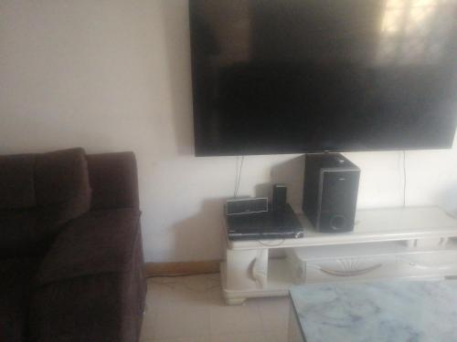 a living room with a television and a table with a couch at Mirema palace in Nairobi