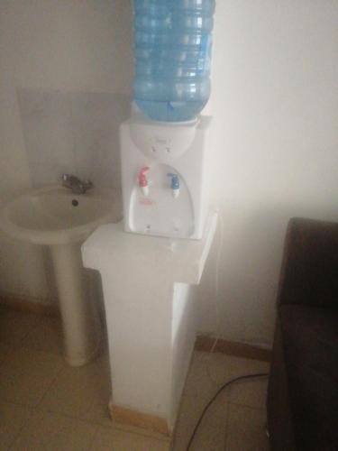 a bathroom with a sink and a bottle of water on a toilet at Mirema palace in Nairobi