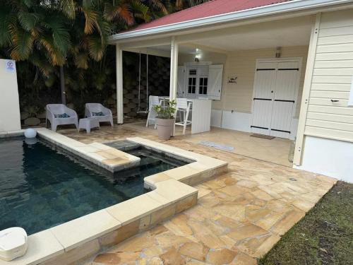 a backyard with a swimming pool and a house at Villa avec piscine privée à Rivière-Salée - 110 m² in Quartier la Fleury Guiné