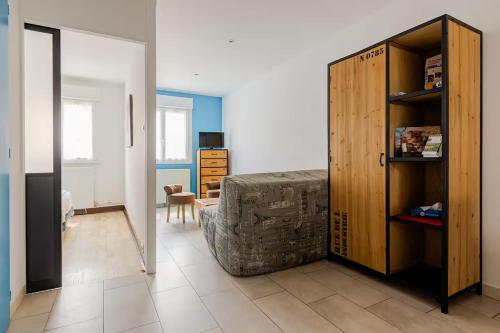 a living room with a couch and a book shelf at Proche Puy du Fou - Petite maison tendance loft in Saint-Laurent-sur-Sèvre