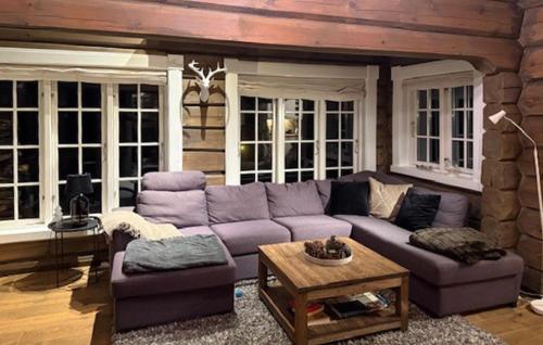 a living room with a purple couch and a table at 4 Bedroom Pet Friendly Home In Svingvoll in Aulstad