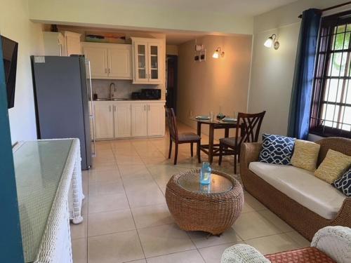 una sala de estar con un sofá y una mesa en Apartment Ellie, en Castries