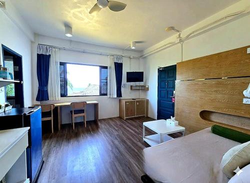 Una habitación con una cama y una mesa y una cocina. en The Rock Samui Poshtel Lamai Beach, en Lamai