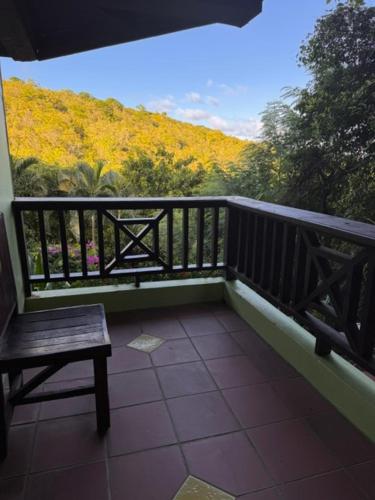 Un balcón con un banco y una vista de flores. en Apartment Ellie, en Castries