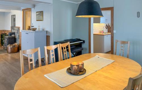 Una cocina y un comedor con mesa y sillas de madera. en Cozy Home In Oppdal With House A Mountain View, en Fagerhaug