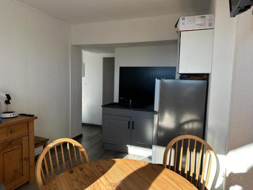 eine Küche mit Tisch und Edelstahlkühlschrank in der Unterkunft Family retreat in the middle of nature Font Romeu in Égat